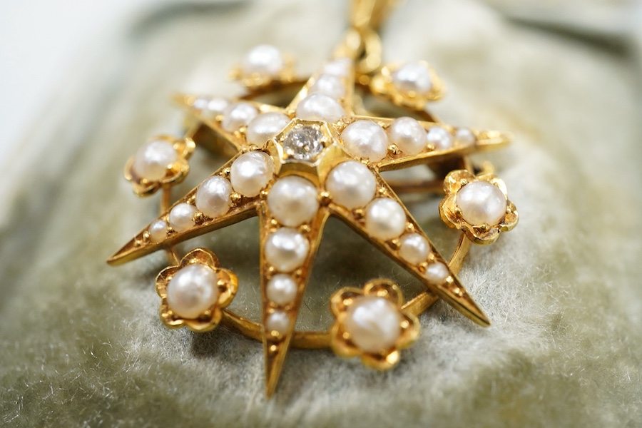 A Victorian yellow metal (stamped 18), diamond and graduated split pearl set star pendant brooch, makers mark SS, 39mm including the bale, gross weight 5.2 grams, with fitted box.